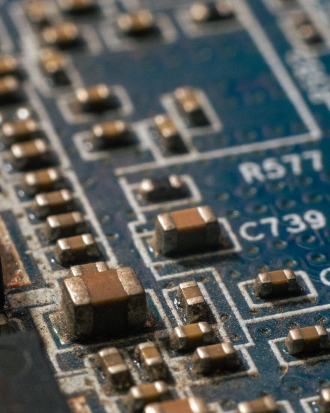 Macro view of a multilayer board showing copper surface-mount components and printed reference designators.